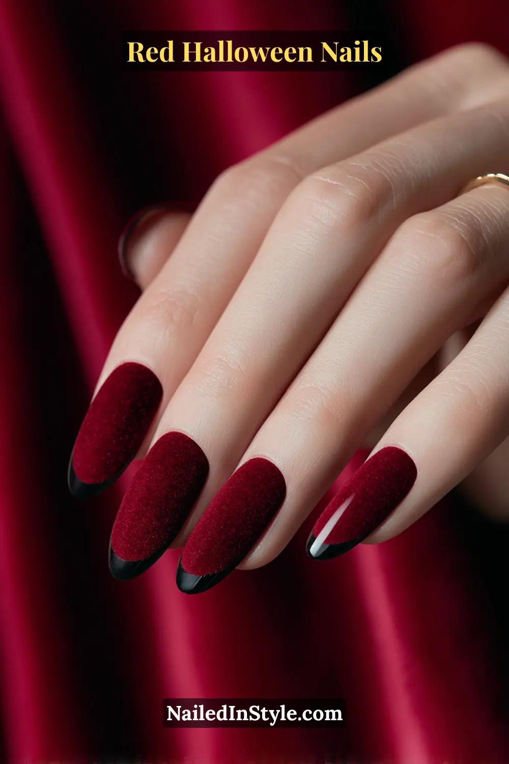 Medium coffin nails in rich crimson velvet with soft black half-tips shaped like subtle fangs; elegant and dramatic against fair to deep skin tones; styled with a black leather strap watch for a refined gothic edge.