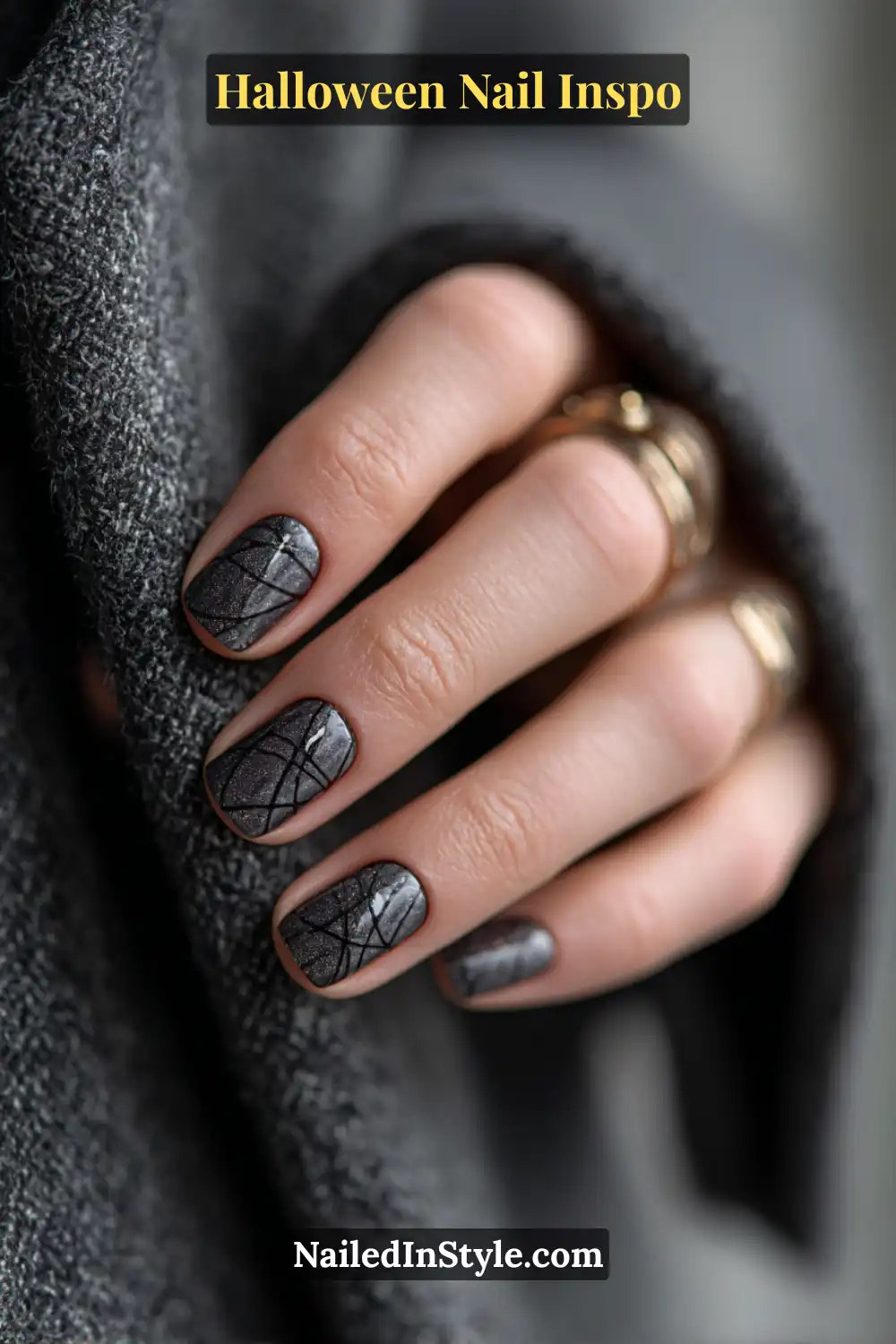 Short round nails in matte charcoal with fine glossy black web-like lines, blending subtle Halloween elegance with soft velvet texture.