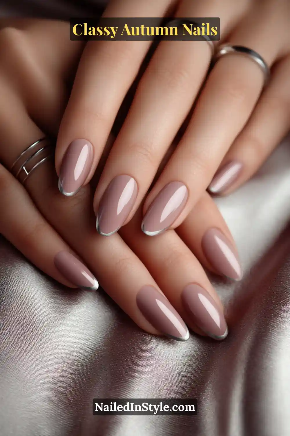 Almond autumn nails in truffle nude with flowing graphite ribbon lines from cuticle to tip, soft satin-inspired look.