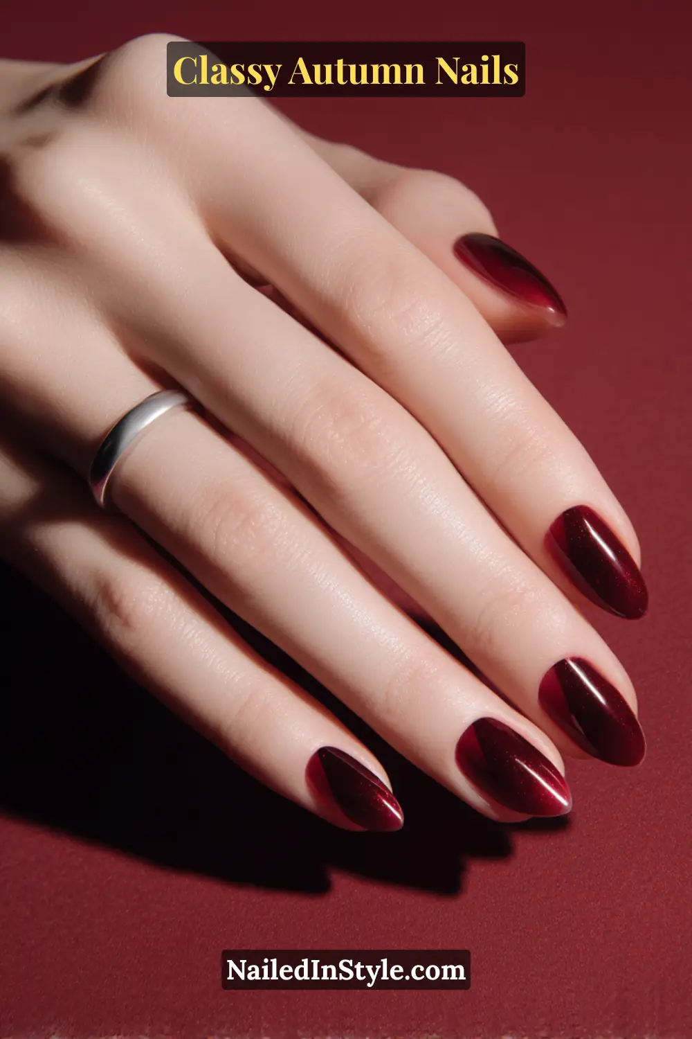 Almond autumn nails with diagonal mulled wine side-sweep and translucent opposite edge, sleek modern finish.