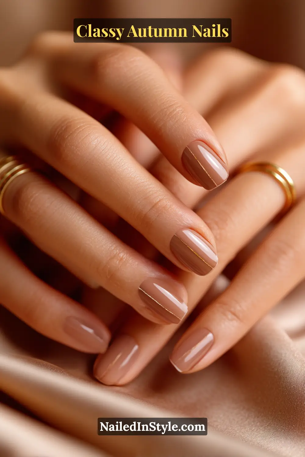 Short autumn nails in café-latte shade with a fine bronze midline accent, paired with gold rings.