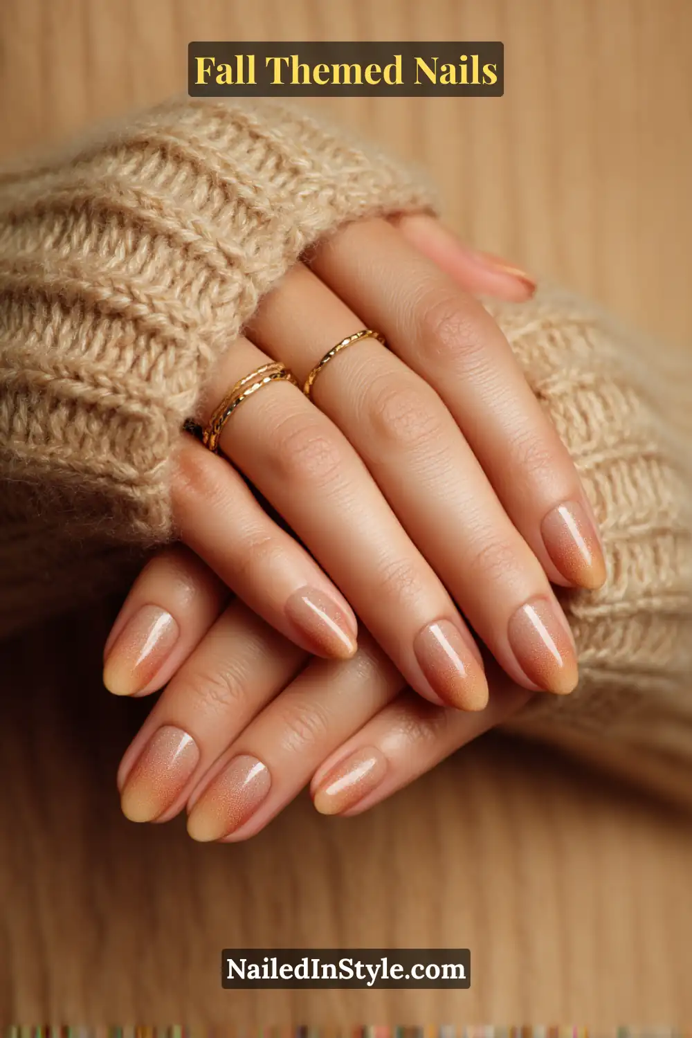 Almond fall nails with saffron to apricot ombré aura glow, paired with gold rings and cozy knit sweater.