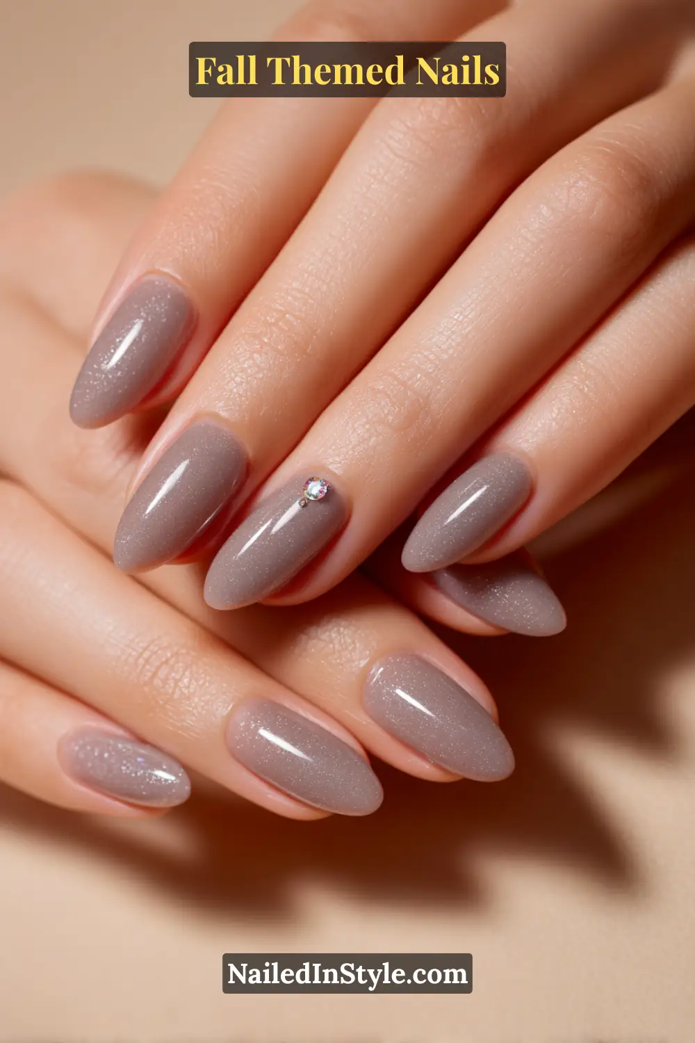 Almond fall nails in smoky grey jelly layered over taupe with a tiny crystal accent, gemstone effect.