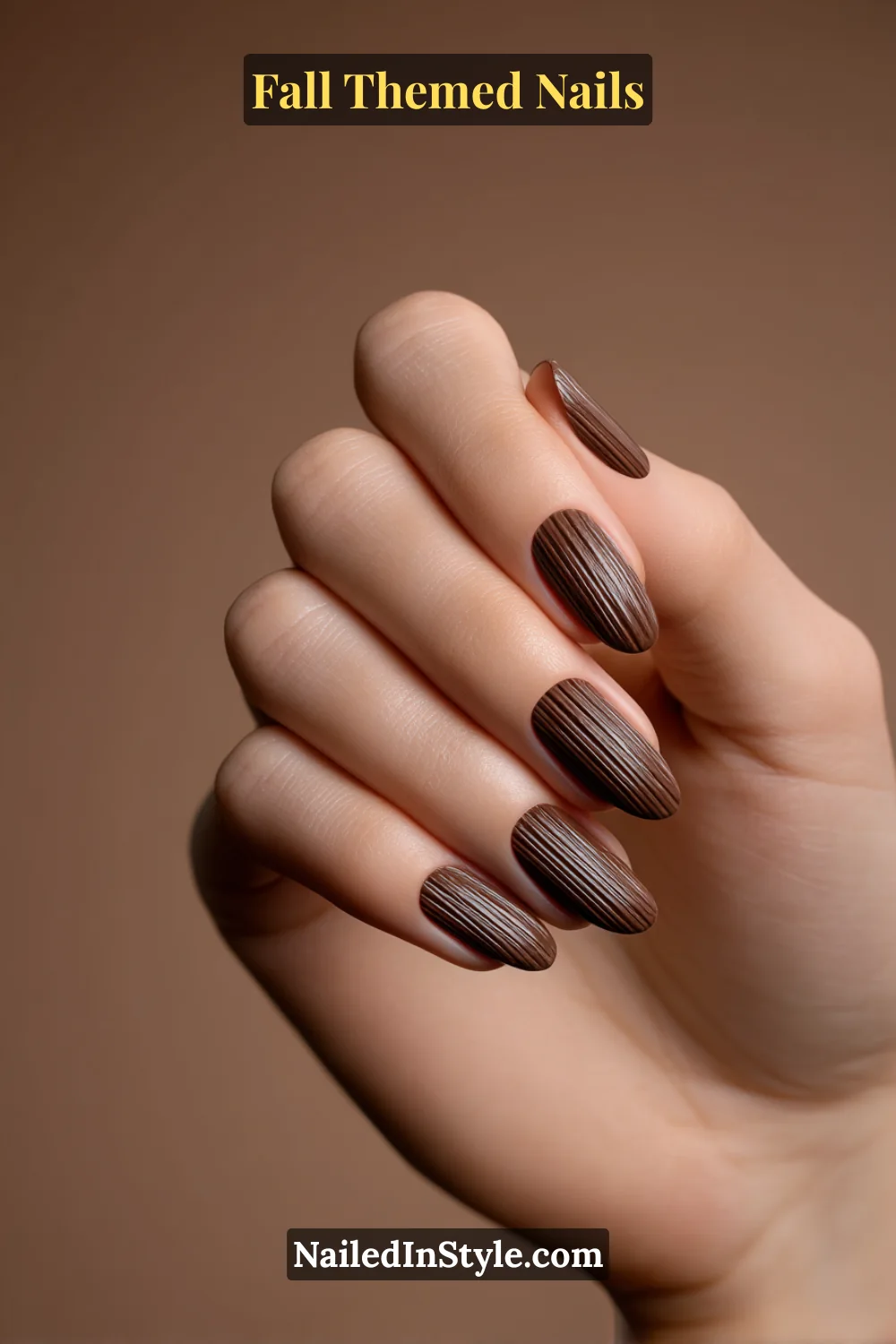 Almond fall nails with matte cocoa base and raised glossy pinstripe corduroy texture, editorial chic.
