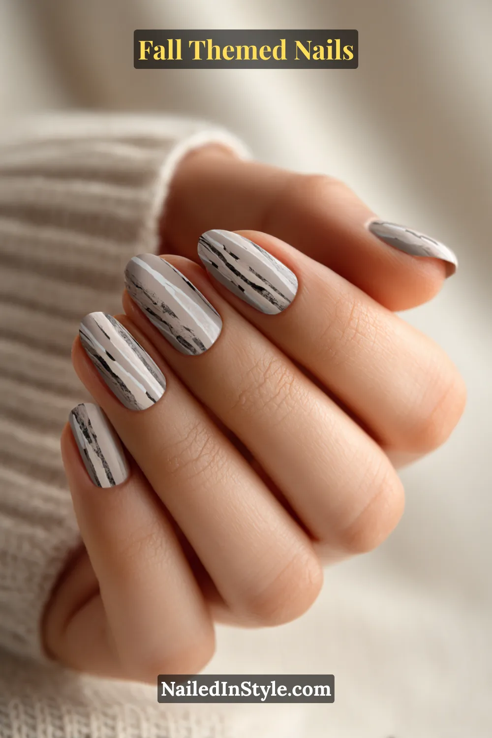 Oval fall nails with soft grey beige base and hand-drawn charcoal bark linework, cozy sweater style.