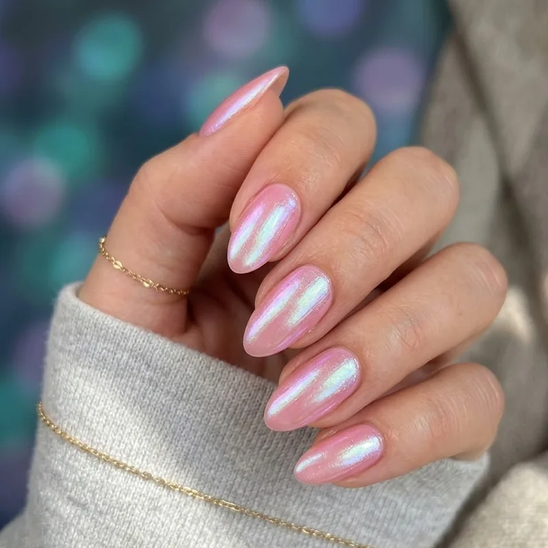 A hand showcasing glossy, iridescent pink almond-shaped nails that capture shimmering underwater hues, perfect for February nail ideas.
