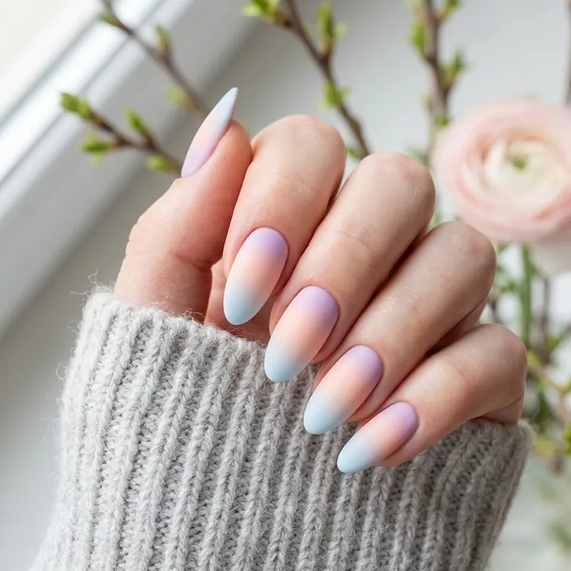 Almond-shaped nails featuring a seamless matte pastel gradient ombre transitioning from soft pink to gentle baby blue for early spring February nail ideas.