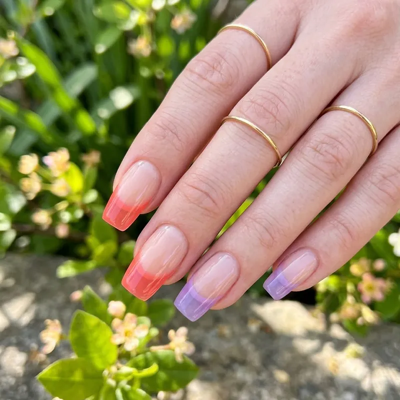 Semi-transparent jelly tip nails in coral and lavender shades.
