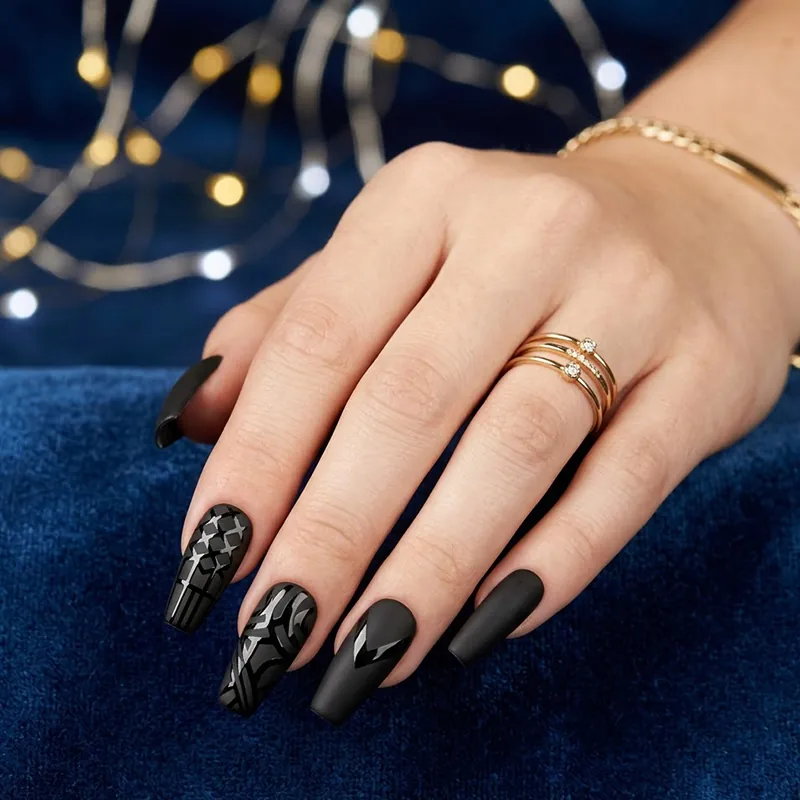 Prom Nails: Your Ultimate Guide to Stunning Styles and Techniques 2026 7 A close-up of long, coffin-shaped prom nails featuring a matte black finish with contrasting high-gloss geometric designs, including micro-grids and abstract swirls, accessorized with gold rings against a blue velvet background.